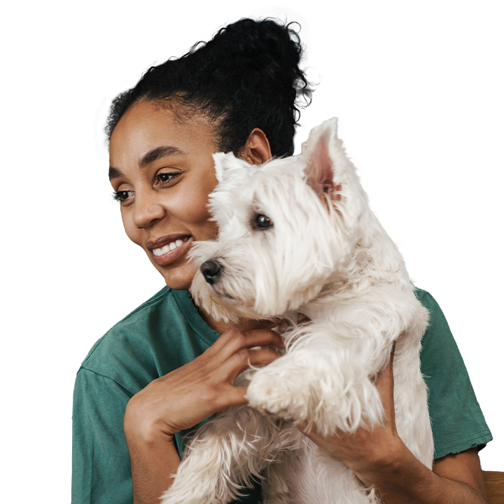 a woman smiling while holding a dog